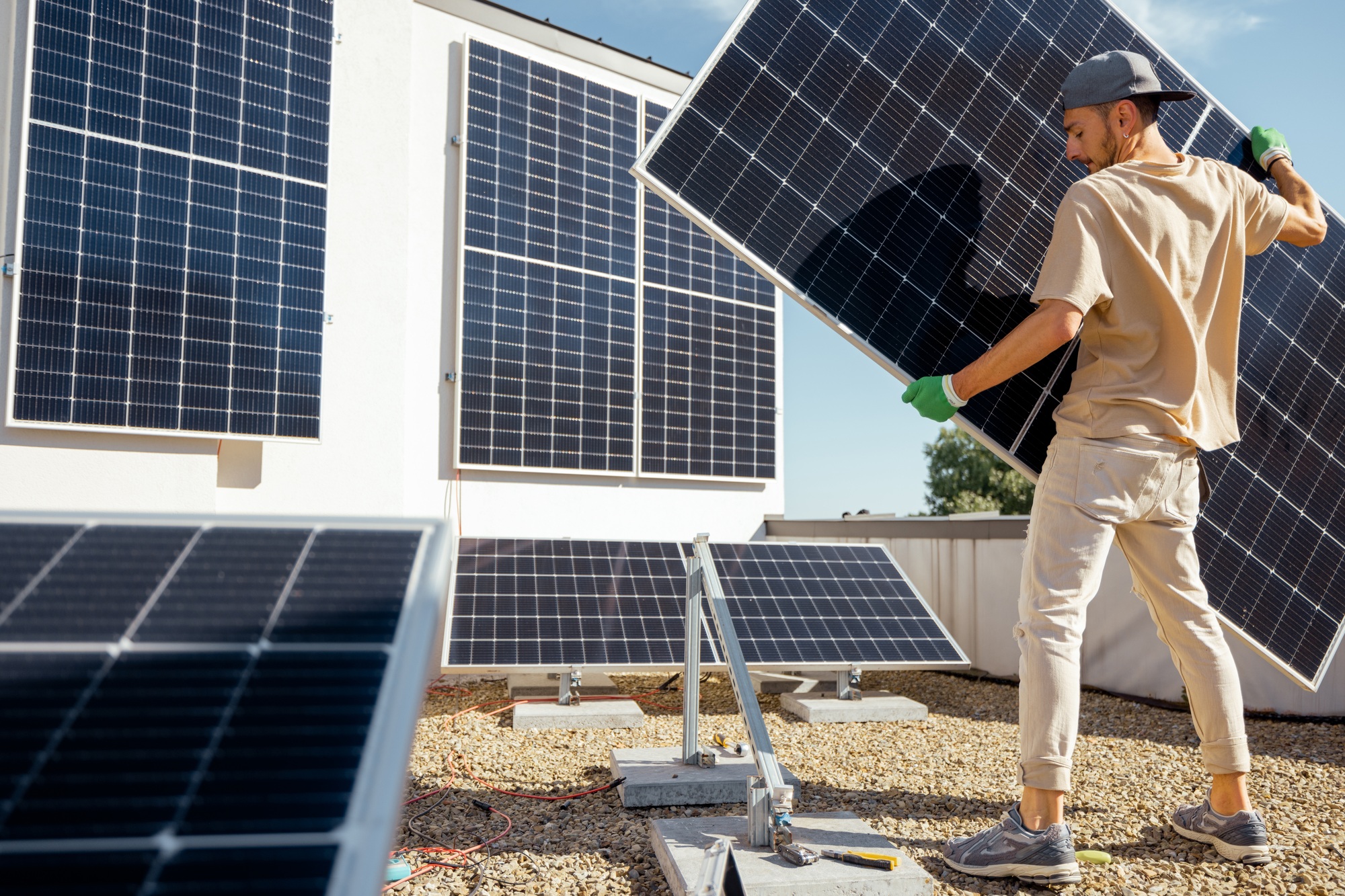 Man installing solar panels on a rooftop